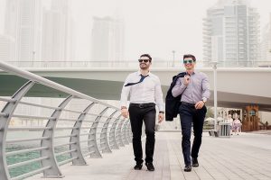Young successful businessman in suit walking in Dubai Marine and