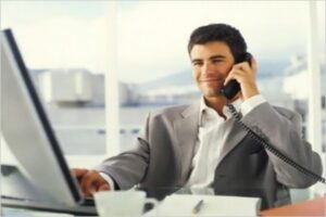 Young businessman using PC and phone