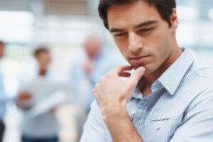 Young business man thinking with colleagues at the back