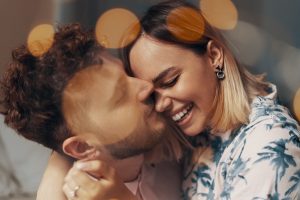 Closeup portrait of lovers. Bokeh effect of garlands. Soft focus image