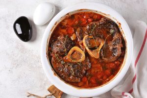 Beef shank stew with onions, carrots, celery, tomatoes, thyme and wine. Top view.