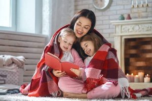 mother reading a book to her daughters