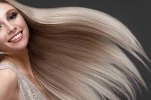 Beautiful blond girl in move with a perfectly smooth hair, and classic make-up. Beauty face.