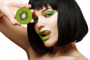 Girl with kiwi. Bright makeup.