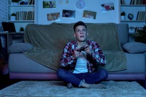 Overemotional teenager plating video game, unstable and uncontrolled emotions