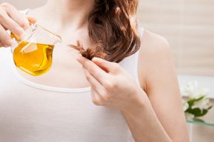 Woman applying oil mask to hair tips