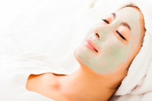 Young beautiful woman with clay facial mask
