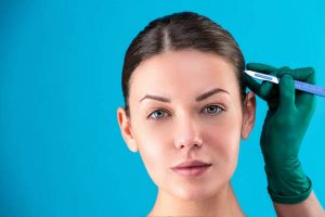 Cosmetic surgeon examining female client in office. Doctor checking woman's face, the eyelid before plastic surgery, blepharoplasty. Surgeon or beautician hands touching woman face.