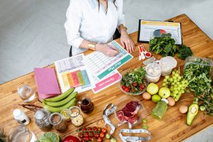 Writing a diet plan on the table full of healthy food
