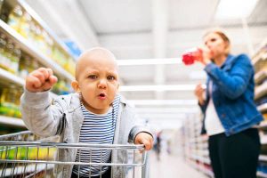 Young mother with her little baby boy at the supermarket.