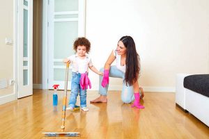 Mother with a child cleans  floor in room. Mum learns