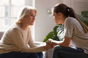 Different generations women talking holding hands giving psychological support