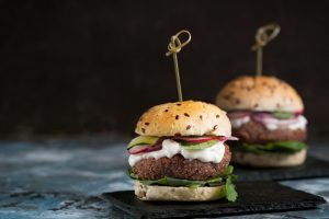 Veggie falafel burgers with fresh vegetables on dark background