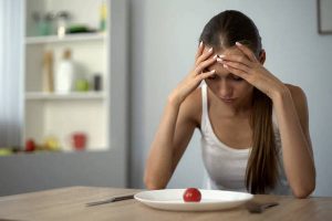 Anorexic girl feels dizzy, depleted by severe diets, exhausted body, starvation
