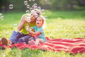 Happy Childhood - Young mother raising her girl child up