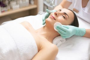 Smiling woman relaxing while having her face cleaned