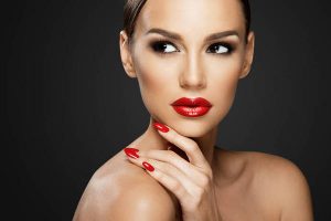 Beautiful woman portrait, beauty on dark background, red nails