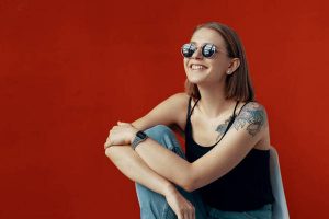 Young girl sitting on a white chair near the red wall