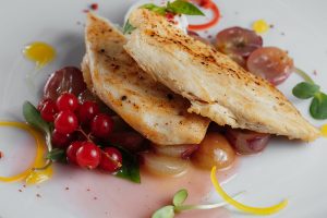 Chicken fillet with grapes and red currant closeup