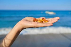 Capsule of vitamin d, e, a, omega 3, fish oil in the hand close-up