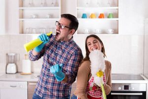 Happy couple singing and doing chores