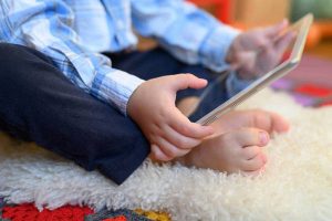 a little boy holds a tablet in his hands