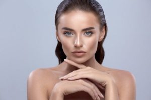 beautiful-woman-on-grey-background-touching-face-beauty-girl-closeup-brunette-model-face-pretty-face-with-arms_355000-2830-600x400