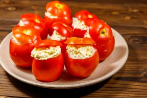 Tomatoes stuffed with cheese on wooden table