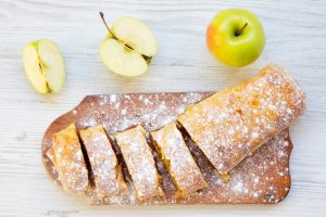 Strudel or apple pie on wooden board. Top view. Closeup.
