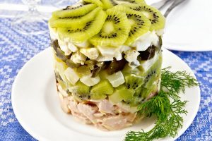 Salad of chicken and kiwi on tablecloth