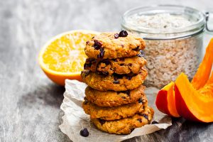 Homemade  pumpkin and orange cookies on rustic wooden background