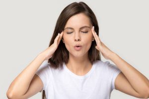 Stressed teen girl calming down massaging temples isolated on background