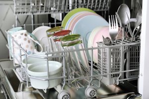 Open dishwasher with clean utensils in it