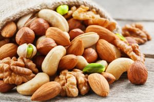Mix,Of,Different,Nuts,In,A,Wooden,Cup,Against,The