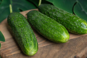 Fresh ripe cucumbers on wooden board