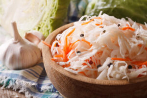 homemade sauerkraut with carrot in a wooden plate